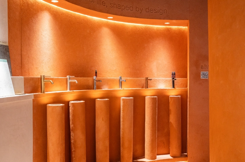 Modern water faucets on textured orange pillars