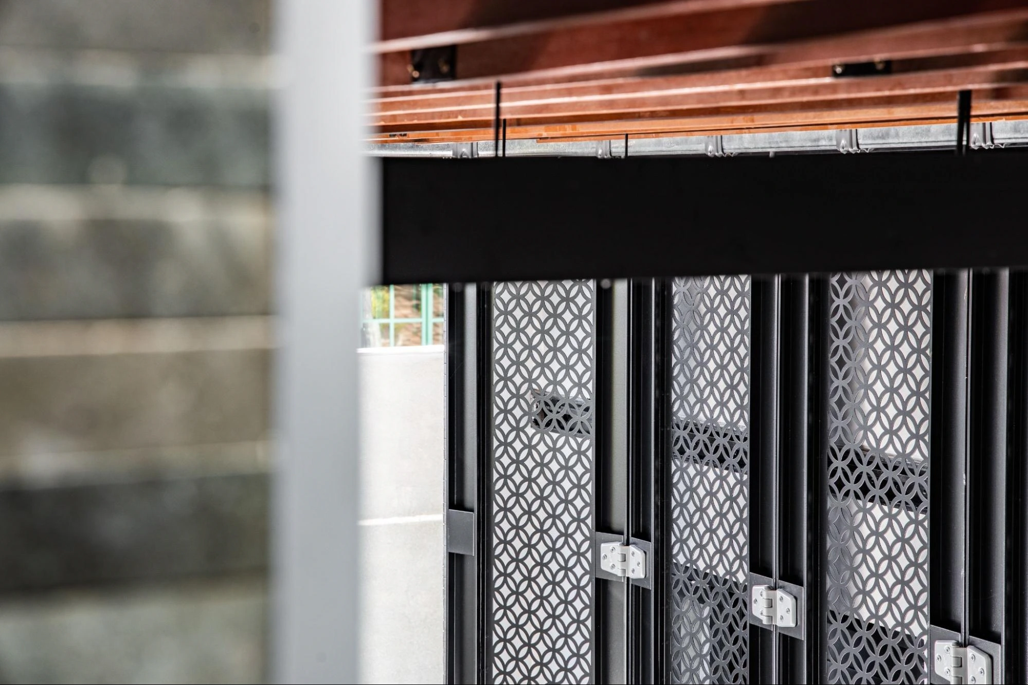 Close-up of a black patterned metal folding gate